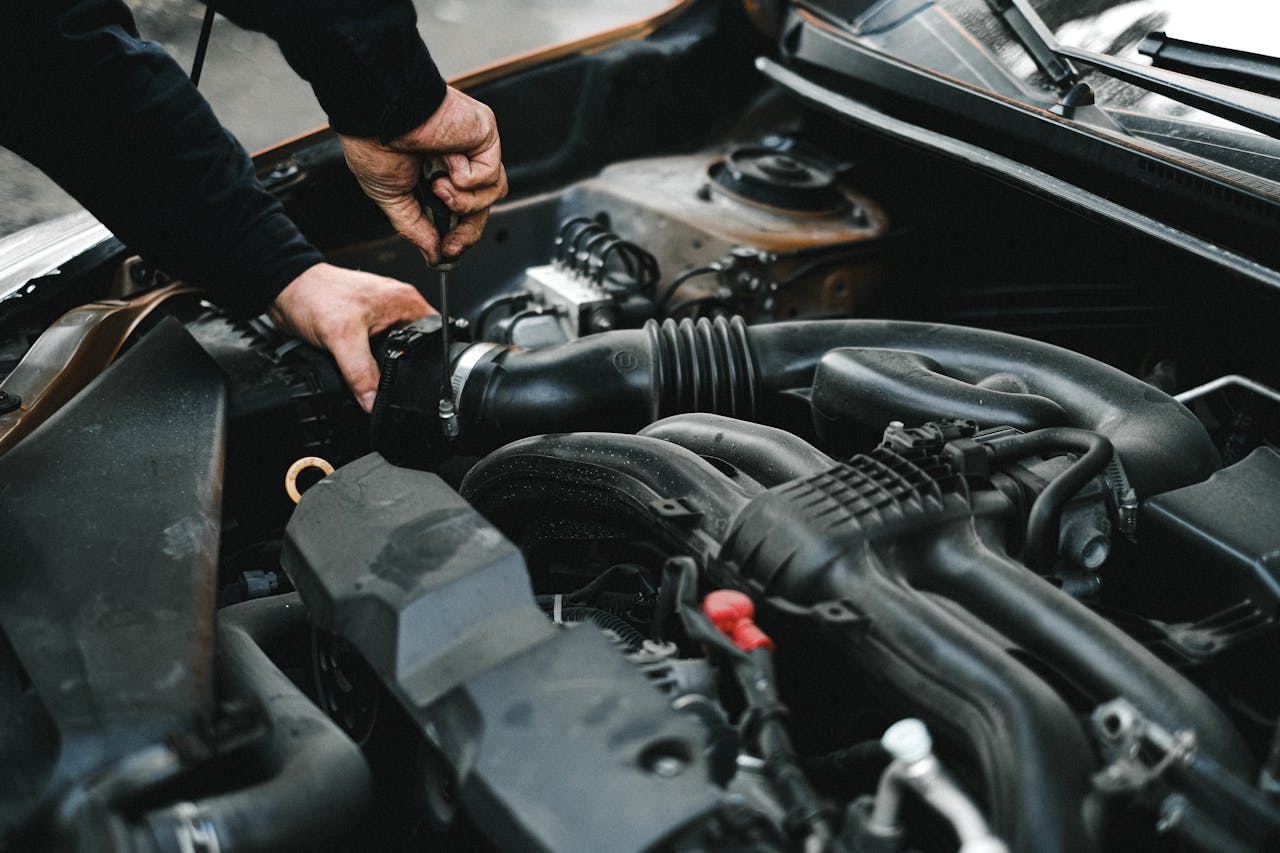 Home Close-up of a mechanic working on a car engine. Ideal for auto repair themes.