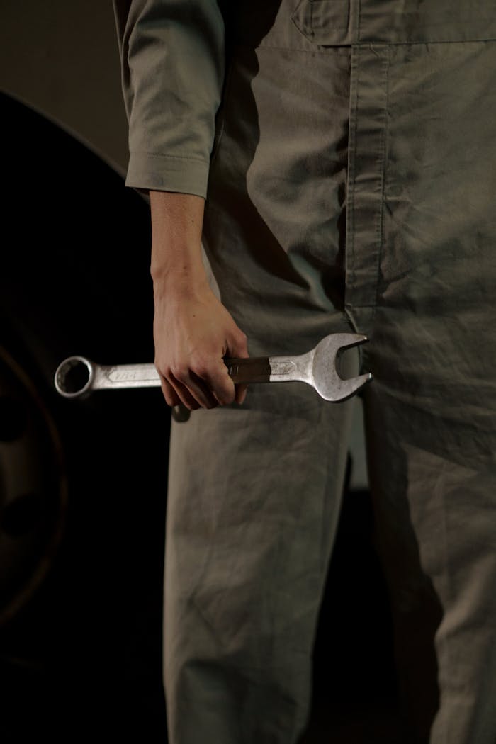 Home Close-up of an auto mechanic holding a wrench in a workshop setting.