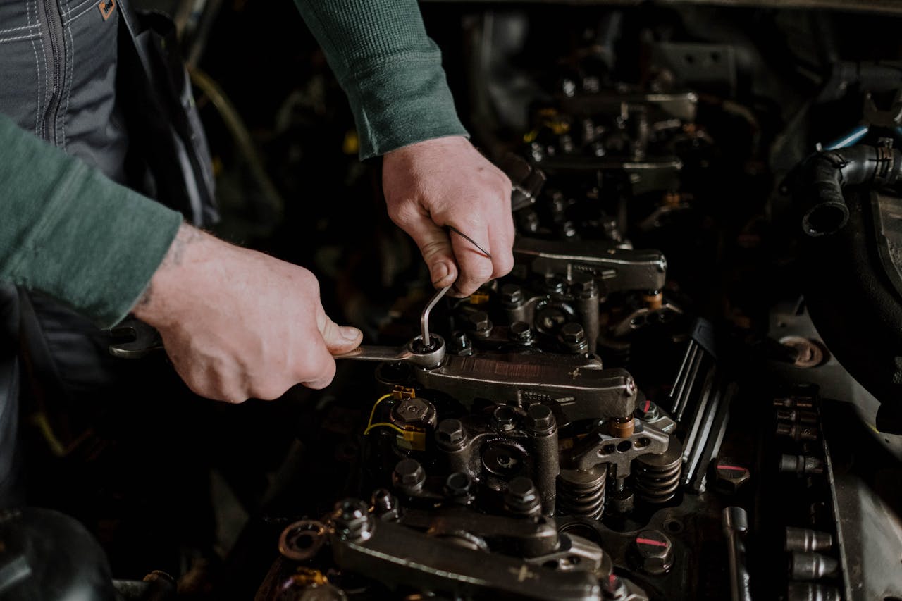 Services Close-up of a mechanic using hand tools to fix an engine, showcasing precision and skill.